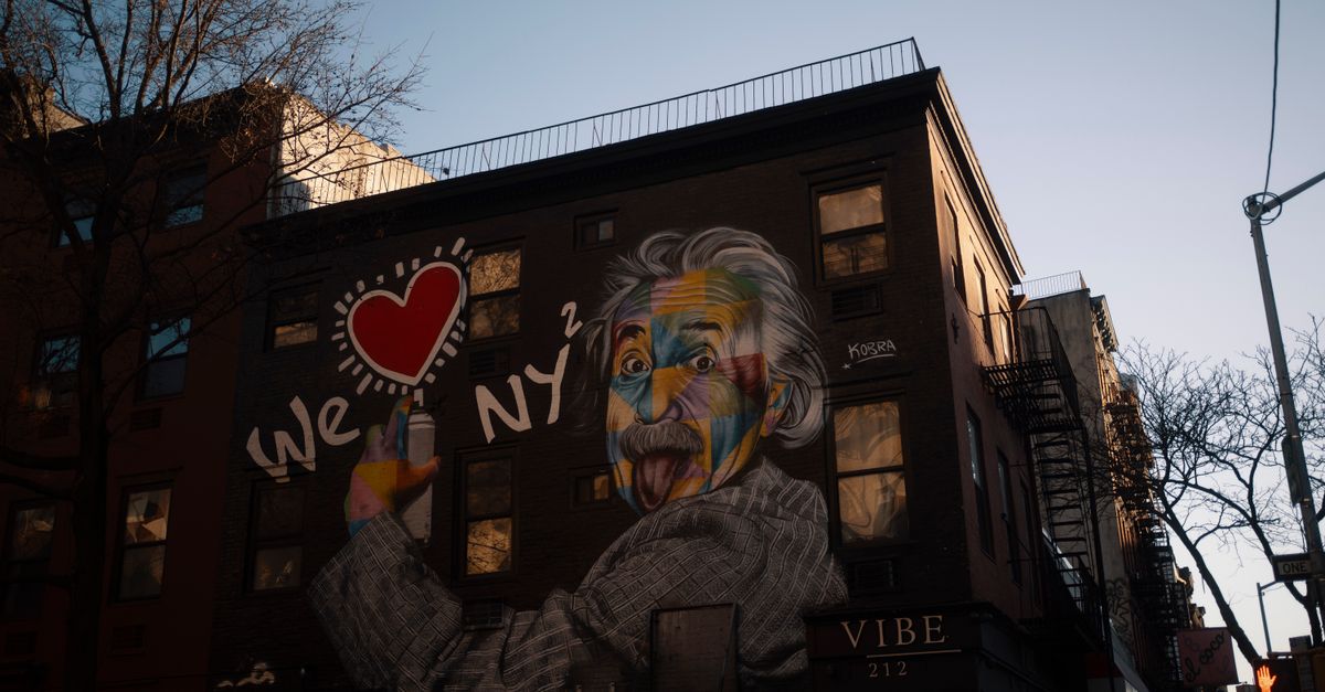 Vivid street art mural of Einstein on New York City building exterior at dusk.